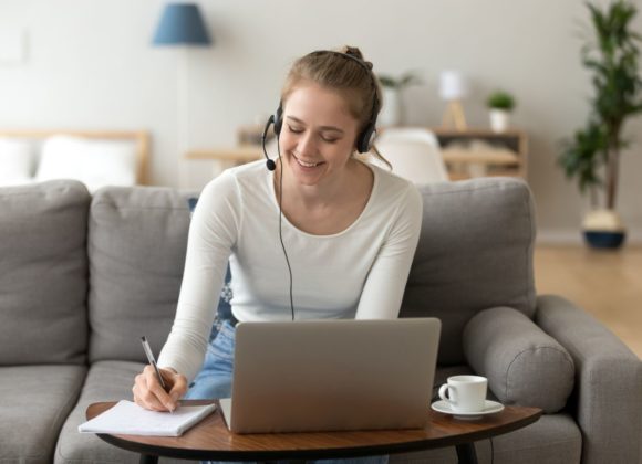 Frau mit Headset am Laptop